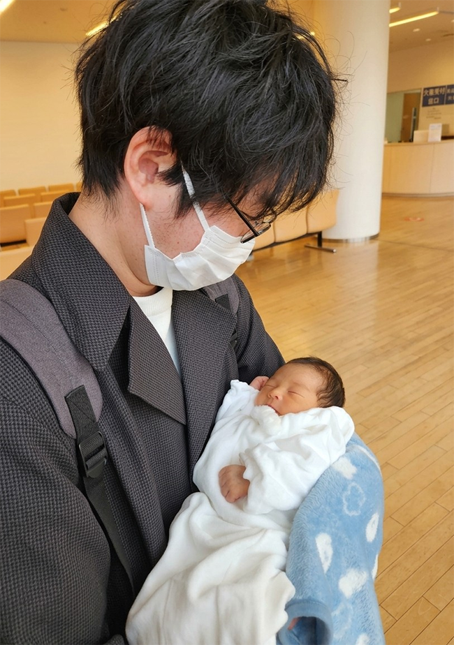 生まれたばかりの我が子を抱く吉田氏。
