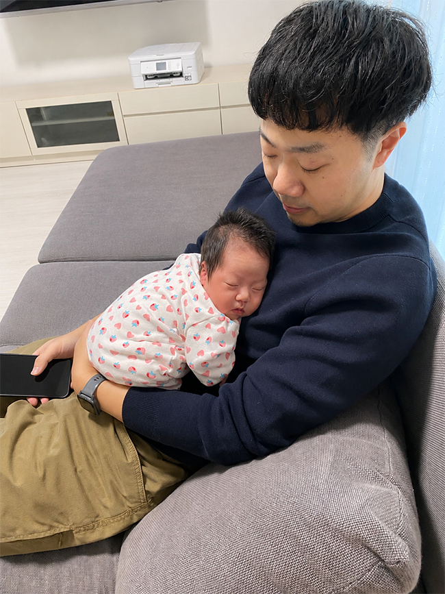生後3週間の我が子を抱く大塚氏。