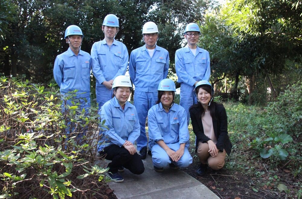 安藤秀康工場長（後列右から２人目）と塚本美那子氏（前列中央）と活動メンバー